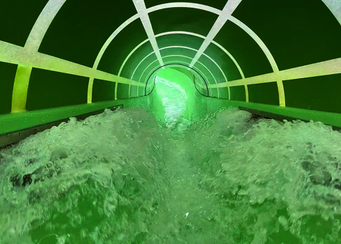 Innenansicht einer Wildwasserfluss Wasserrutsche mit starker Strömung und Tageslichteffekten.