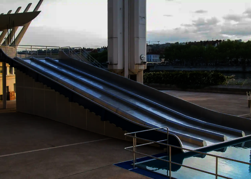 Multilane im Freibad mündet direkt ins Schwimmbecken neben einem Turm.