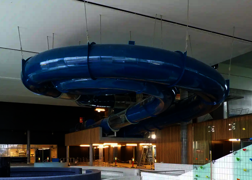 Eine blaue RR1200 Wasserrutsche in einem Hallenbad.