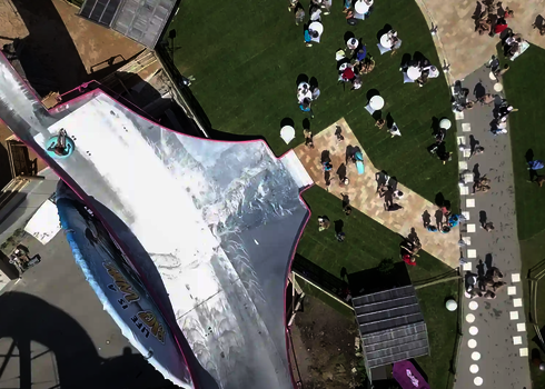 Ein Gast rutscht auf einem Reifen die Sidewinder-Rutsche hinab, gesehen von oben.