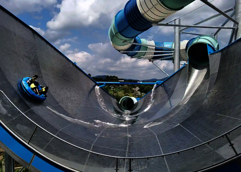 Blick von hinten auf dem Urknall mit mehreren Personen in einem Rutschreifen.