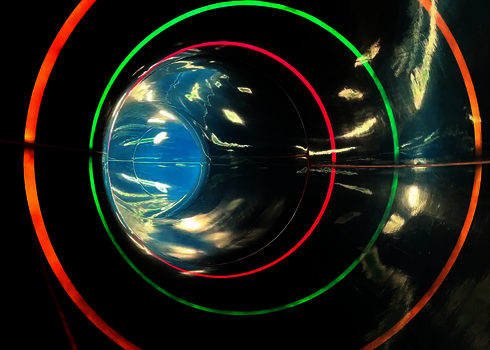 Schwarze Röhrenrutsche mit bunten Lichtstreifen.