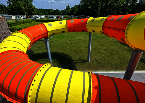 Gelb-orangener Family Twister, der in eine RR900-Kids Wasserrutsche übergeht.