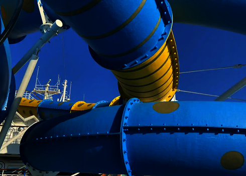 Eine blau-gelbe RR900 Wasserrutsche auf einem Kreuzfahrtschiff vor blauem Himmel.
