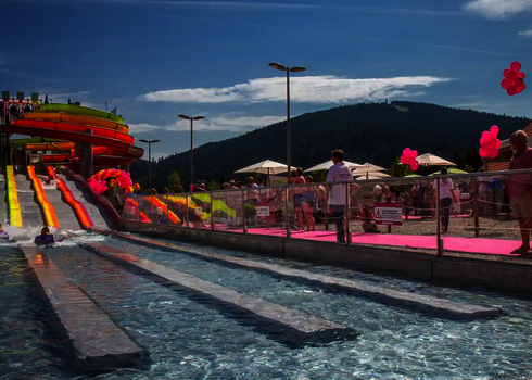 Blick auf die Wasserrutsche Matracer mit Startbereich, Zuschauern und Auslaufbecken.