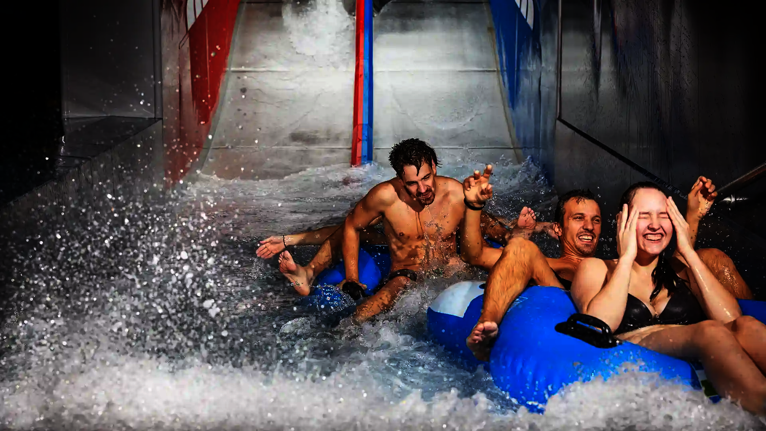 Glückliche Badegäste im Wasserbecken nach der Fahrt mit der Raft Racer Reifenrutsche.