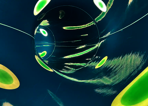 Innenansicht einer blauen Röhrenrutsche mit Lichteffekten in Form von Streifen und Punkten.