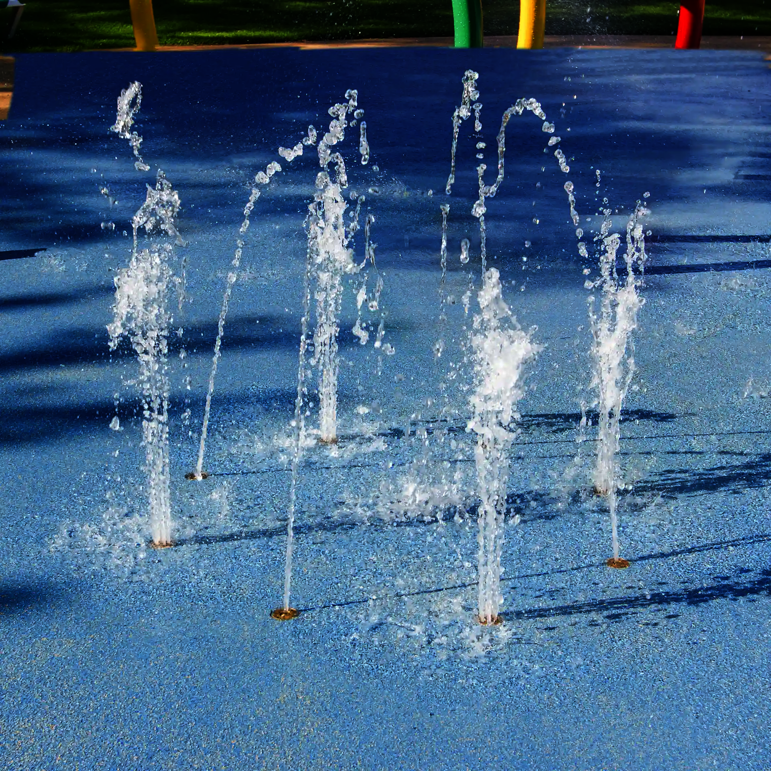 Nahaufnahme des Wie-Spray Elements "Wasserring", kleine Wasserfontänen spritzen aus dem Boden.