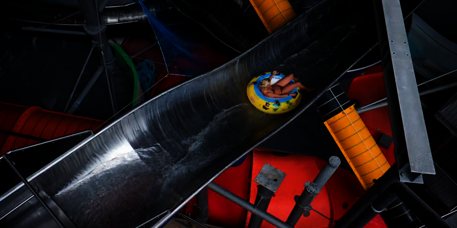 Blick von oben auf eine Person in einem Rutschreifen in einer Crazy River Wasserrutsche aus Edelstahl.