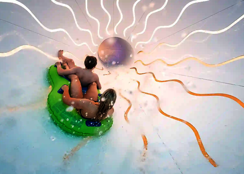 Frau und Kind rutschen im Crazy Cone mit Tageslichteffekten und spritzendem Wasser.