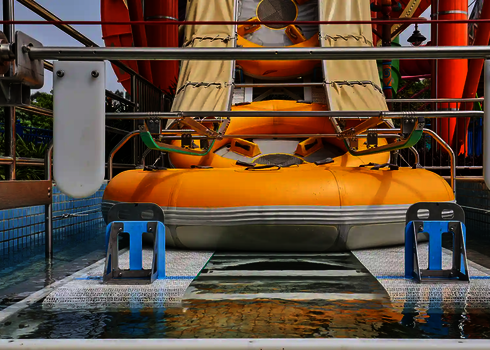 Two yellow slide rafts are transported upwards side by side by the raft conveyor.