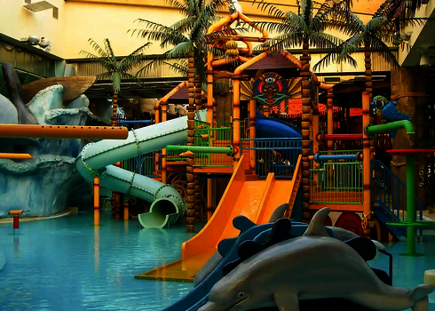Hallenbad mit großer Wasserspielstruktur mit einer RR900-Kids, einer Multislide und weiteren Kinderrutschen.
