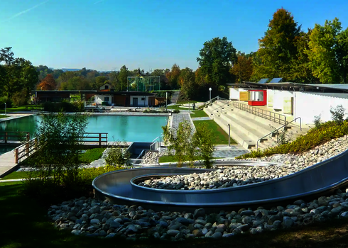Edelstahl-Wasserrutsche WR1040 mit mehreren Kurven an einem Hang in einem Freibad.