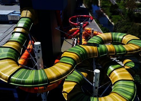 Luftaufnahme bunter Family Twister Wasserrutschen mit grün-gelben und roten Kurven.