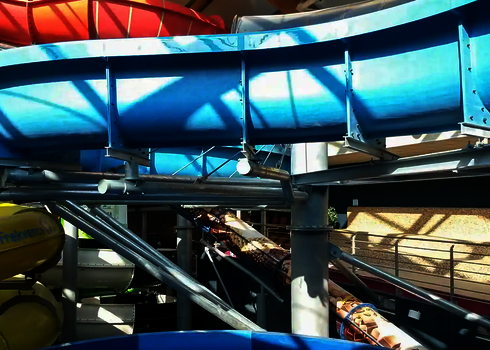 Mehrere farbenfrohe Wasserrutschen, getragen von Stahlstützen.