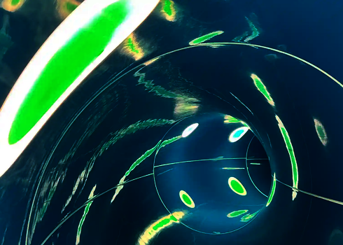 Innenansicht einer Wasserrutsche mit Lichteffekten in Form von Streifen und Punkten.