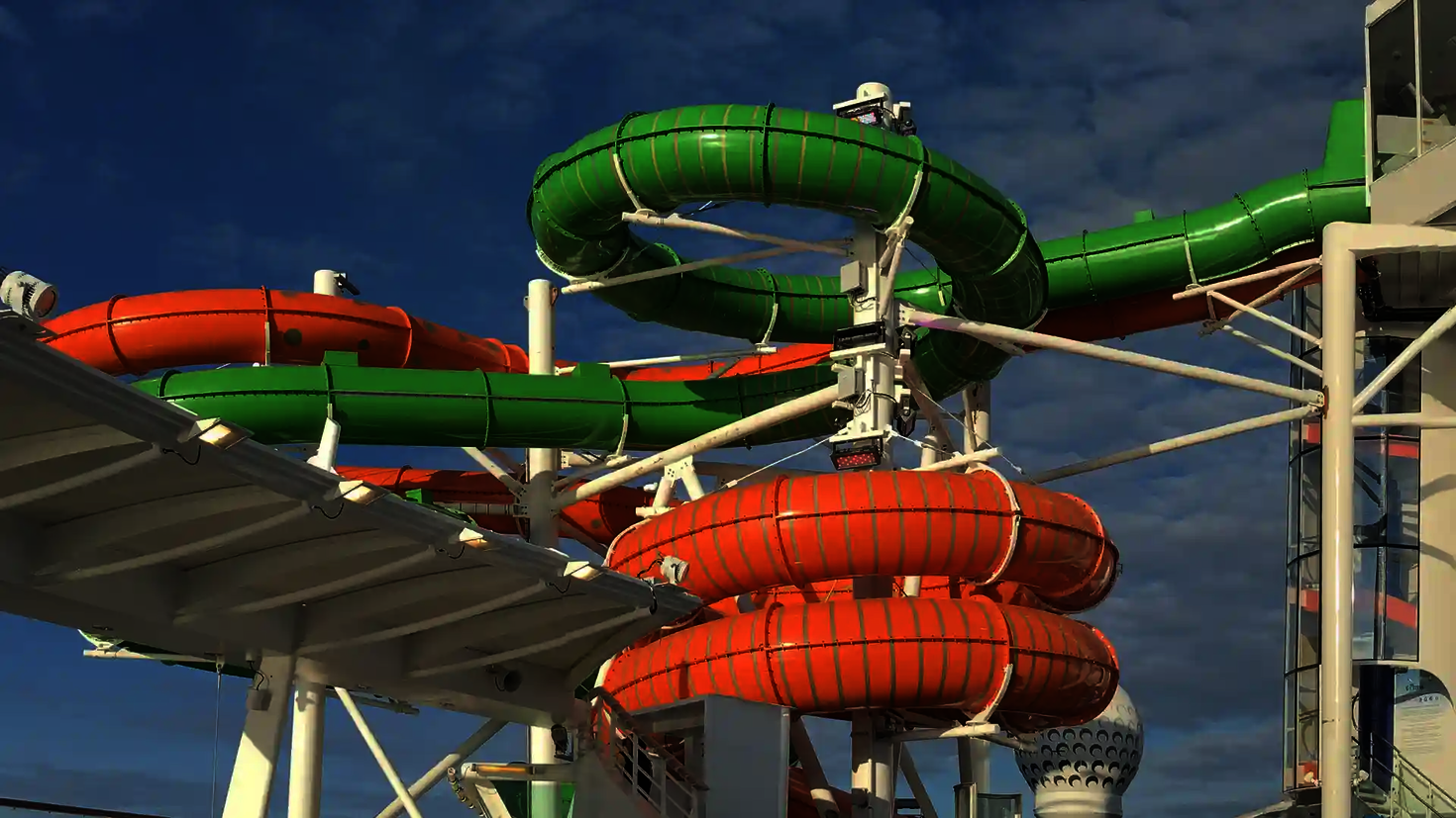 Grüne und orange Röhrenrutschen mit glatter Außenfläche auf einem Kreuzfahrtschiff.