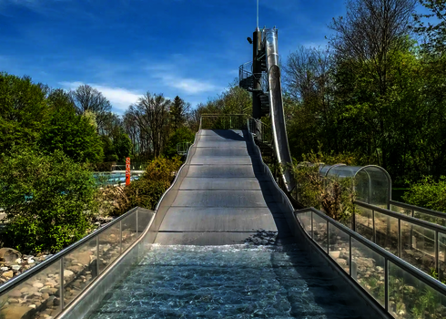 Breitwellenrutsche in einem Schwimmbad, daneben befindet sich ein Freifall.