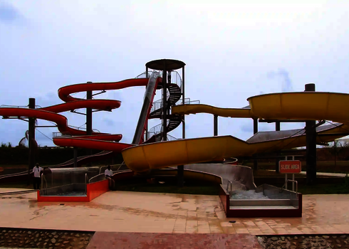 Rote Wasserrutsche und gelber Crazy River unter freiem Himmel.
