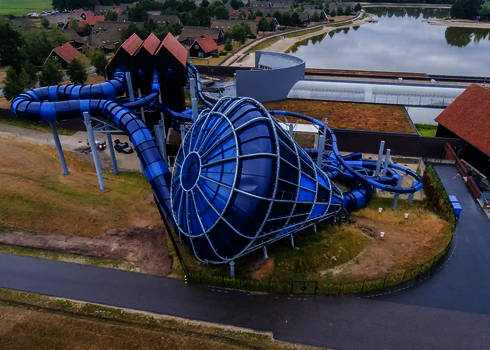 Rückansicht des blauen Cyclone mit großer Trichteröffnung und geschwungener Röhrenrutsche.