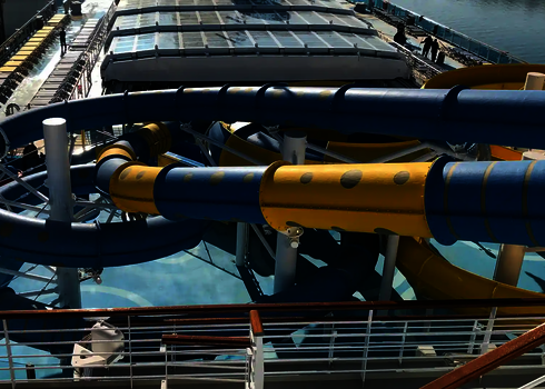 Blau-gelbe RR900-Rutschen verlaufen verschlungen über das Oberdeck eines Schiffs.