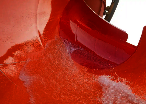 Nahaufnahme zeigt spritzendes Wasser in einer orangenen Kurve der Reifenrutsche RR2700.