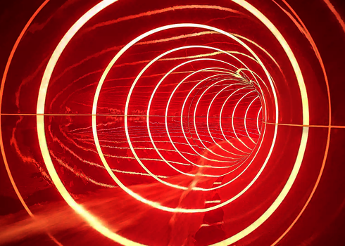 Innenansicht einer roten Wasserrutsche mit Tageslichteffekten in Form von Streifen.