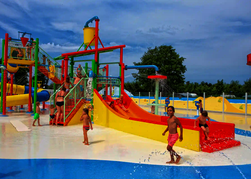Bunte Wasserspielstruktur im Kinderbereich in einem Wasserpark, Kinder spielen und rutschen.