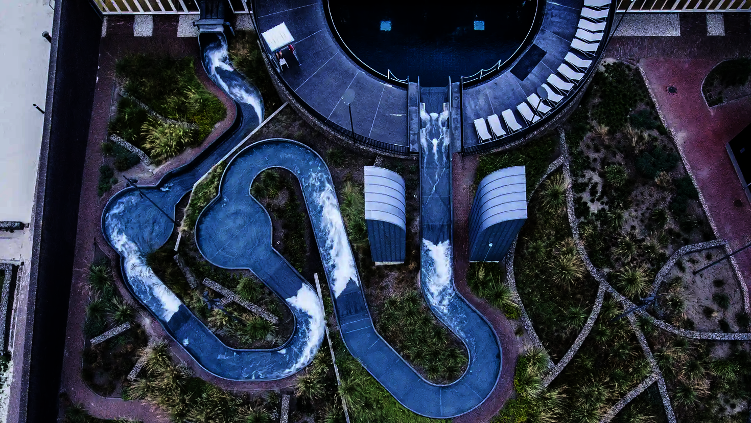 Vogelperspektive auf den kurvigen Wildwasserfluss auf dem Außengelände eines Wasserparks.