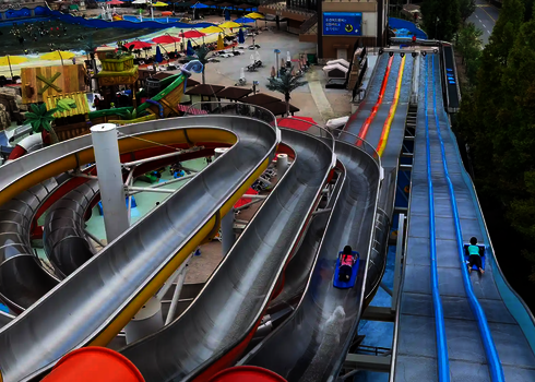 Blick von oben einer Matracer Rutsche auf spiralförmig und gerade verlaufende Rutschenabschnitte.