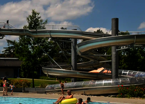 Edelstahlrutsche WR1040 in einem Freibad mit Menschen am Beckenrand.