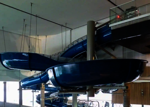 Blauer Crazy River in einem überdachten Schwimmbad, mit Stahlseilen und Stützen befestigt.