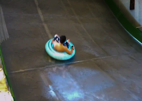 Junge rutscht im Einzelreifen die Sidewinder im Innenbereich hinab.