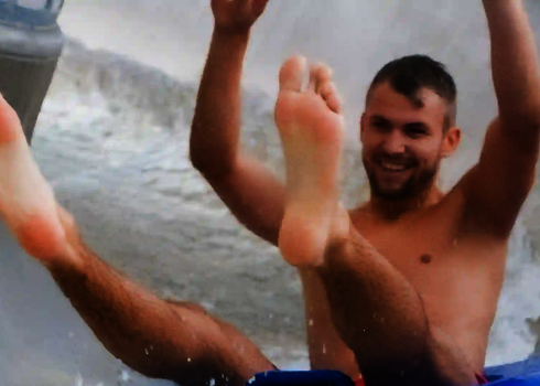 Nahaufnahme eines Mannes, der mit erhobenen Händen rutscht.