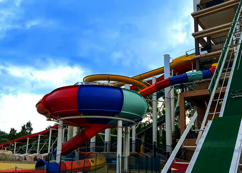 Bunte Body Bowl im Außenbereich mit rot-blau-grüner Farbgestaltung und weiteren Rutschen.