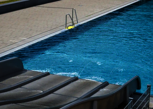 Seitenansicht der Multilane im Freibad mit Wasserstrahlen am Beckenrand.