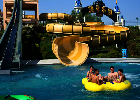 Gruppe junger Männer landet mit dem Reifen nach der Abfahrt der Reifenrutsche RR2700 im Wasserbecken.