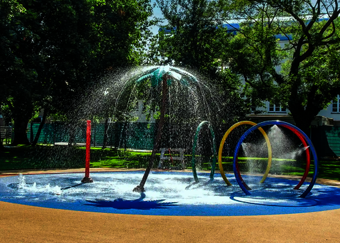 Wasserspielplatz mit sprühenden Wie-Spray Elementen unter freiem Himmel.