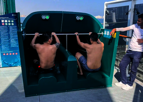 Zwei Männer in Startposition auf der 2-in-1 Racer Doppelwasserrutsche, betreut von einem Mitarbeiter.