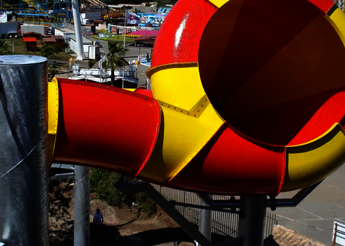Blick von oben auf den gelb-roten Trichter des Crazy Cone in einem Freizeitpark.