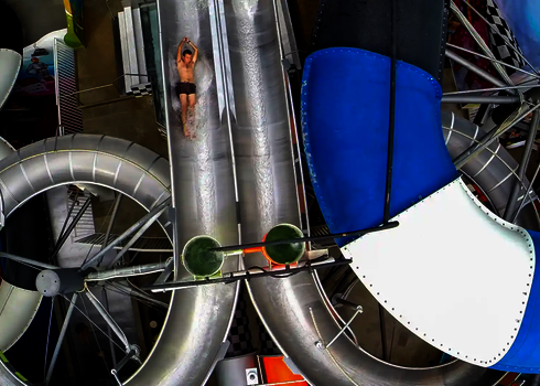 Rutschende Person in der Body Racer Wasserrutsche aus der Vogelperspektive fotografiert.