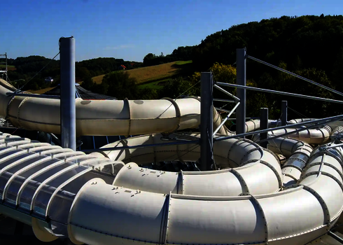 Gesamtansicht der geschwungenen Raft Racer Rutschenelemente im Außenbereich.