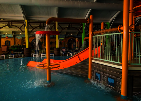 Wasserspielstruktur in brau und orangetönen in Hallenbad und Pool.