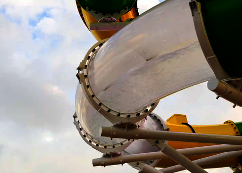 Transparenter Abschnitt der RR900 schwenkt in einem Bogen über grün-gelbes Rohr.