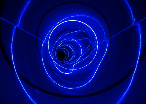 Blaue LED-Ringe ziehen sich spiralförmig durch das Innere der Röhrenrutsche.