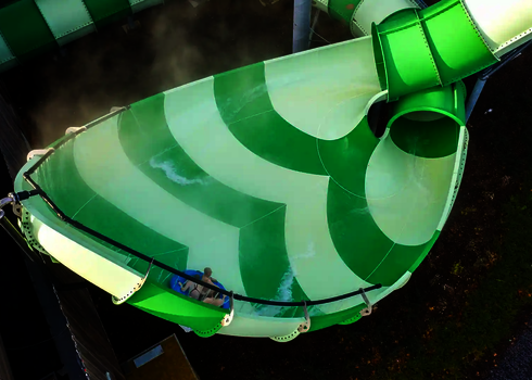 Blick von oben auf die grüne Lotus Reifenrutsche mit einer rutschenden Person.