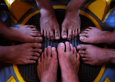 Nahaufnahme von mehreren Füßen, die auf dem Boden eines Reifens stehen.