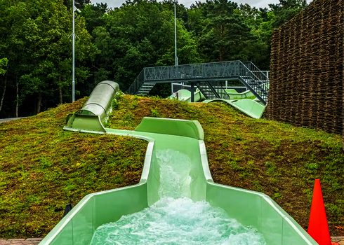 Blick auf den ersten Anstieg und Tunnelbereich des grünen Wildwasserflusses.