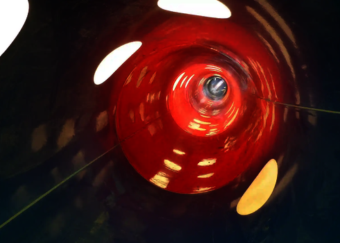 Innenansicht einer blau-roten Röhrenrutsche mit Tageslichteffekten.