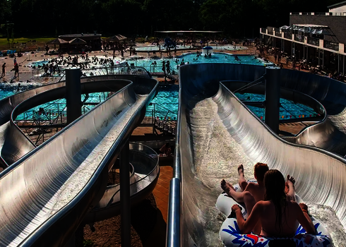 Blick von oben auf Crazy River Rutsche mit zwei nebeneinander verlaufenden Bahnen im Einsatz.